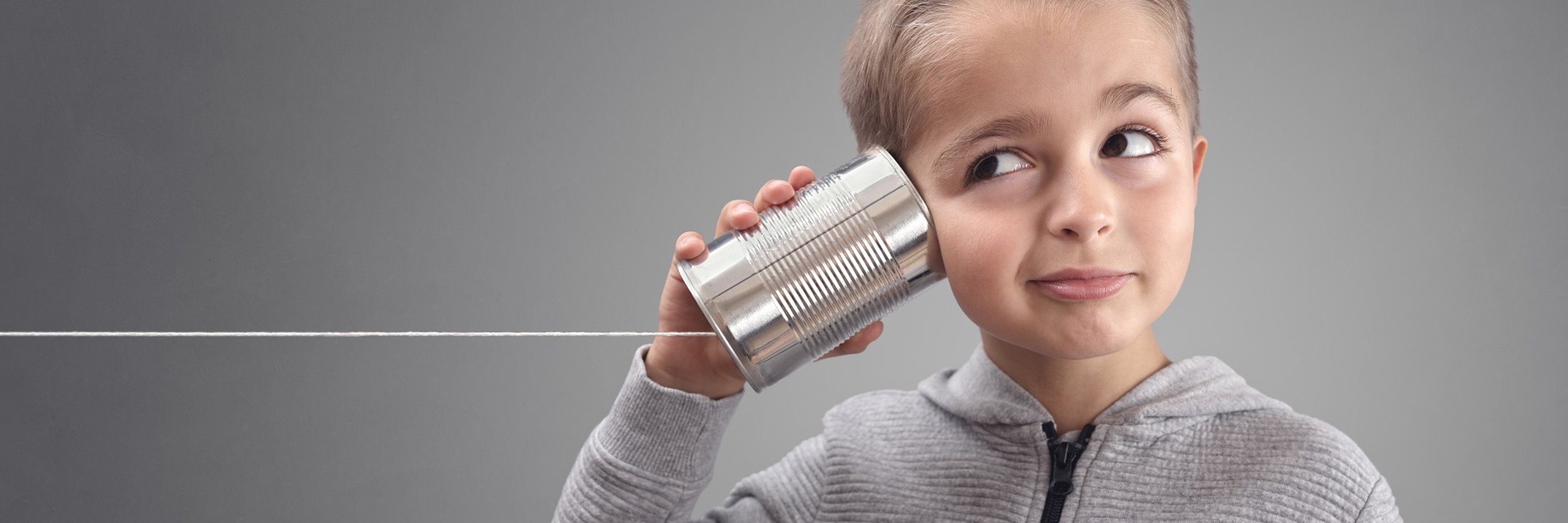 Boy on tin can phone listening to curious good news