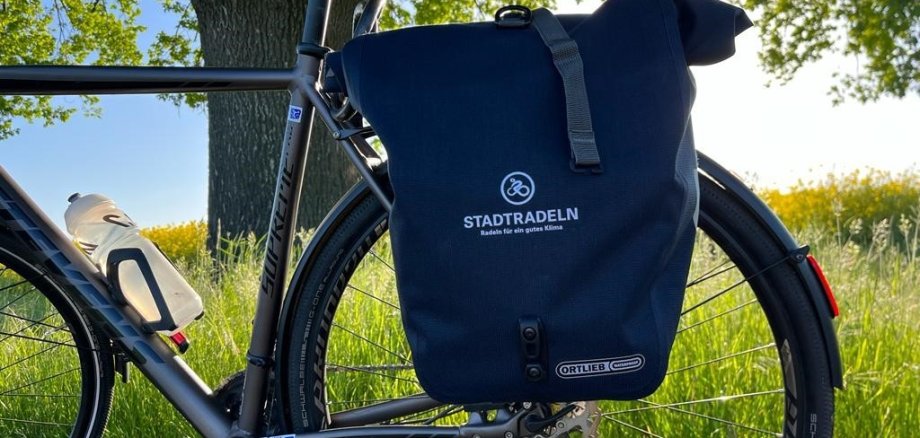 Ein abgestelltes Herrenrad mit einer Fahrradgepäckträgertasche sowie einer 