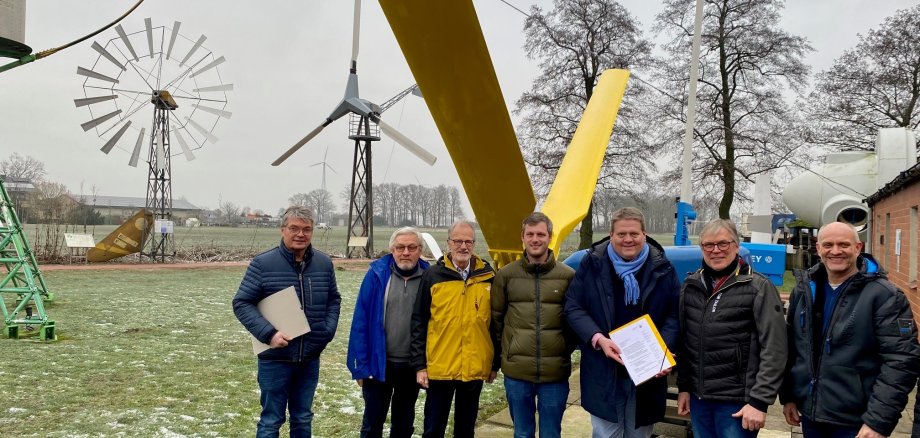 Gruppenfoto mit sieben Männern auf dem Gelände des Deutschen Windkraftmuseums.