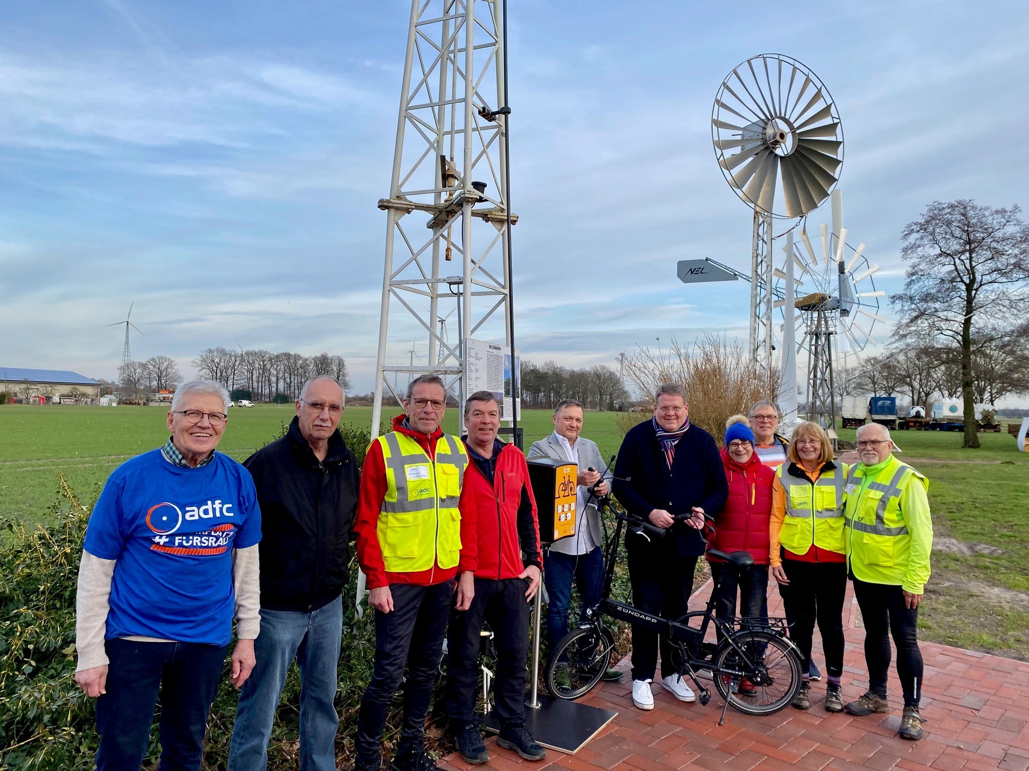 Ladesäule Windkraftmuseum 1 Eine Gruppe von Männern und Frauen, die an einer Ladesäule für E-Bikes stehen.